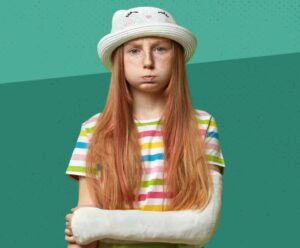 Potrta deklica na zelenem ozadju - otrosko nezgodno zavarovanje